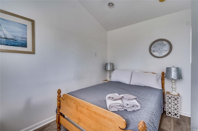 27180 Montonna Shores Rd N, Lyme, NY 13693 - bedroom featuring vaulted ceiling, baseboards, and wood finished floors