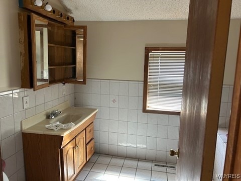 90 Alma Ave, Buffalo, NY 14215 - bathroom featuring tile walls, wainscoting, vanity, and a textured ceiling