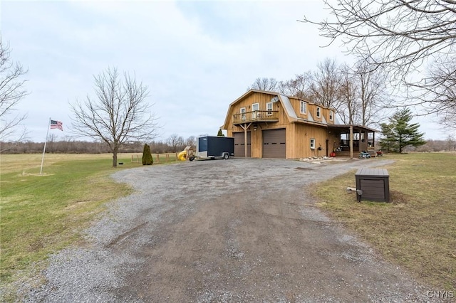exterior space with a detached garage, dirt driveway, a gambrel roof, and a front lawn