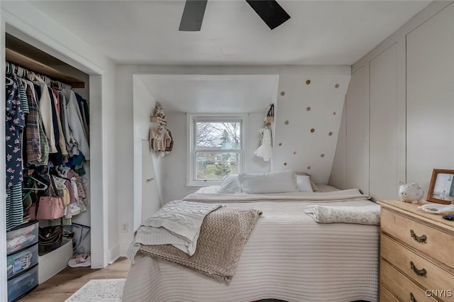bedroom featuring ceiling fan, a closet, and light wood-type flooring