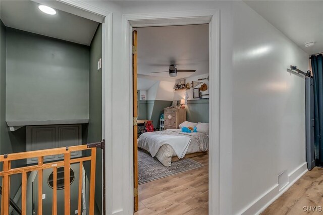 bedroom featuring a barn door and wood finished floors