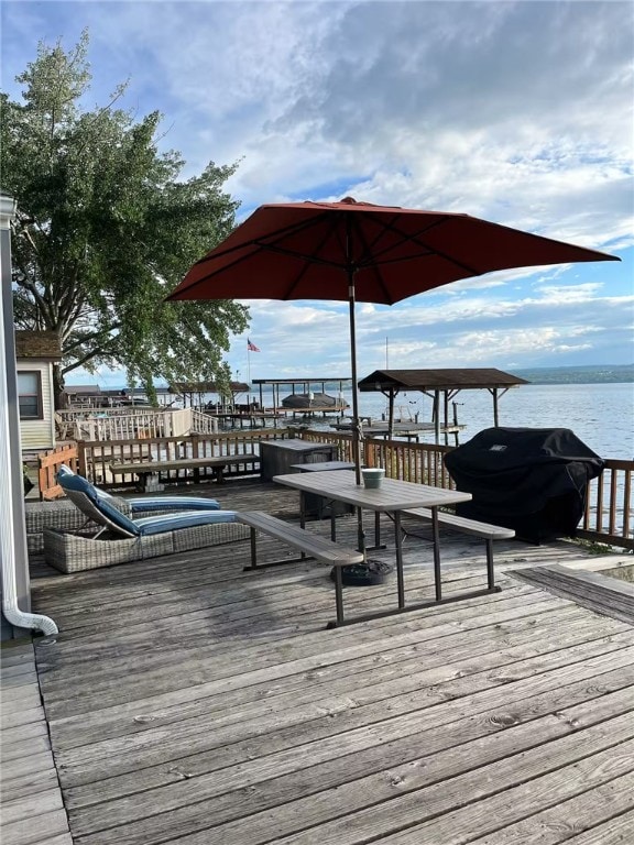 deck with a grill and a water view