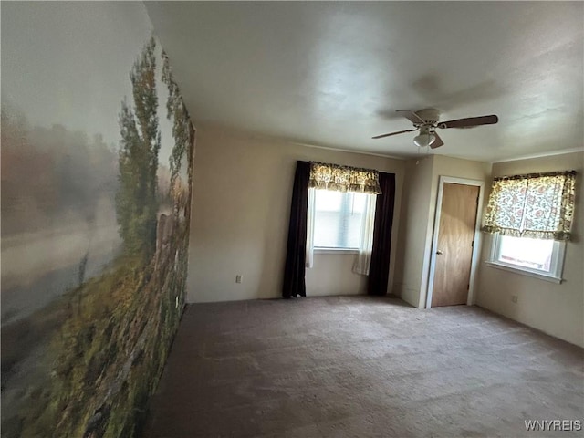 unfurnished bedroom with carpet floors, a ceiling fan, and multiple windows