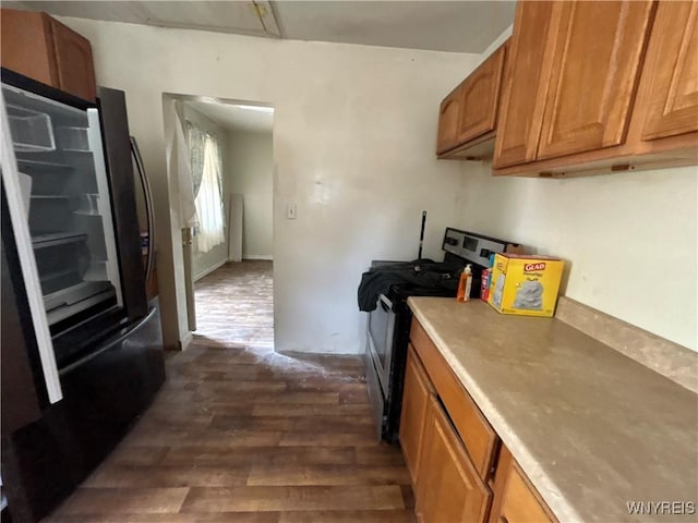 254-256 Bird Ave, Sidney, NY 13838 - kitchen featuring fridge, dark wood-style floors, stainless steel range with gas cooktop, brown cabinetry, and light countertops