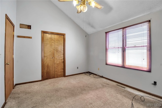 unfurnished bedroom featuring vaulted ceiling, ceiling fan, carpet floors, baseboards, and visible vents