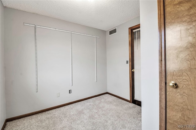 unfurnished bedroom with a textured ceiling, carpet floors, visible vents, and baseboards