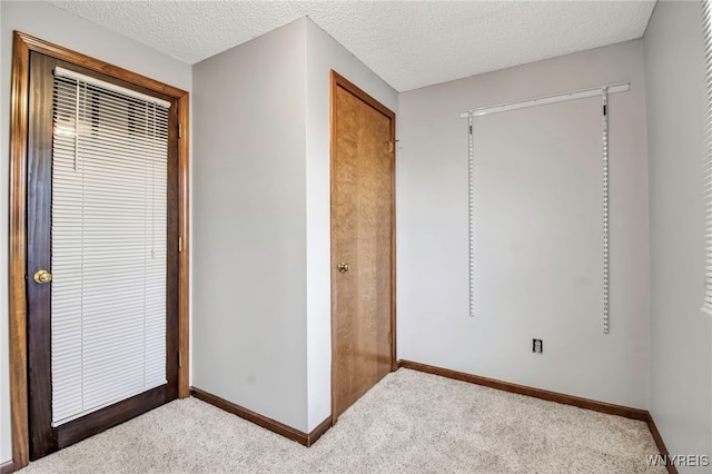 unfurnished bedroom featuring baseboards, carpet, and a textured ceiling