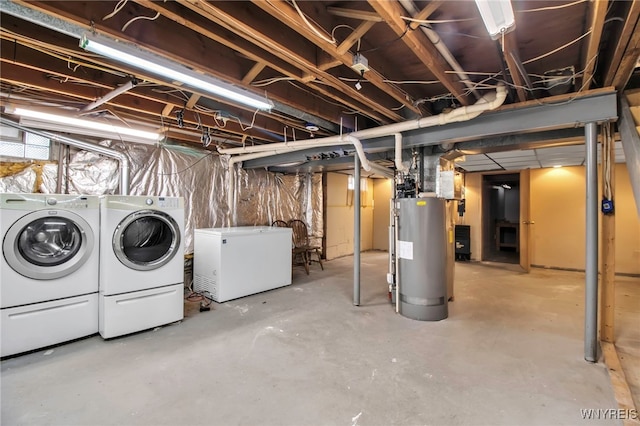 unfinished below grade area featuring water heater, washer and dryer, and fridge