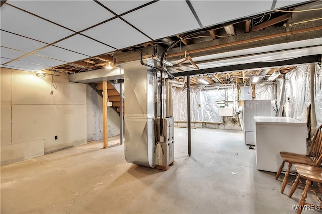 basement with stairway, heating unit, and a sink