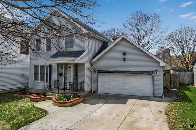 traditional-style home with an attached garage, driveway, and fence
