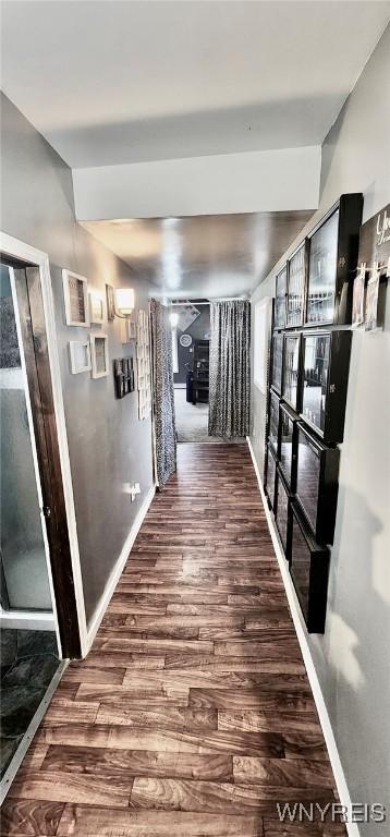 hall featuring wood finished floors and baseboards