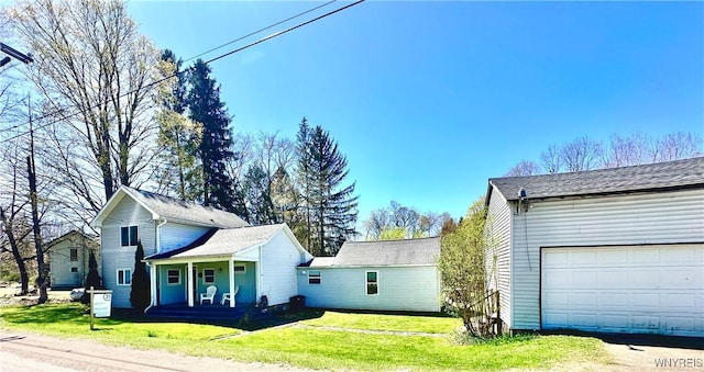 view of property exterior featuring a lawn, covered porch, and a garage