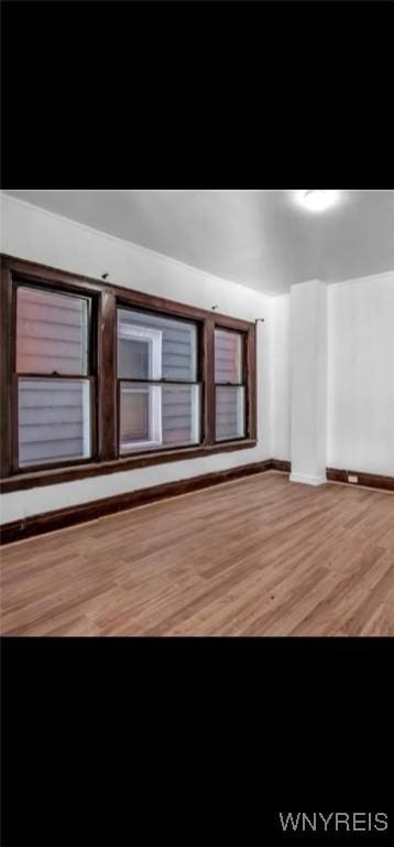 unfurnished room featuring baseboards and wood finished floors