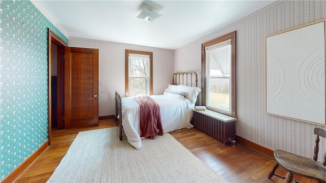 4501 State Route 414, Hector, NY 14818 - bedroom with radiator, baseboards, wallpapered walls, wood finished floors, and ornamental molding
