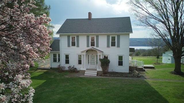 4501 State Route 414, Hector, NY 14818 - colonial house featuring roof with shingles, a chimney, and a front yard