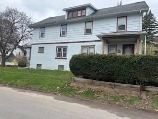 american foursquare style home featuring a front yard