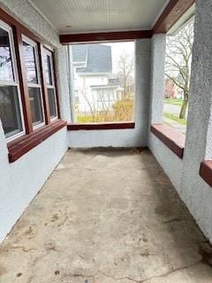 unfurnished sunroom with concrete flooring and plenty of natural light