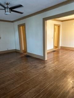 empty room featuring ornamental molding, baseboards, and dark wood finished floors