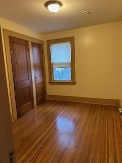 unfurnished bedroom with wood finished floors and baseboards