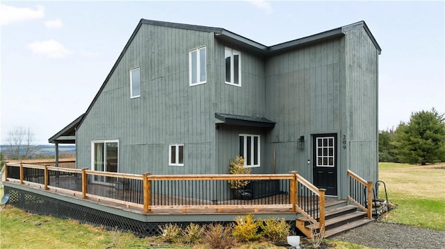 back of property with a yard and a deck