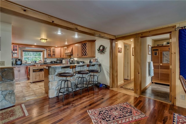 8521 N Shore Rd, Diana, NY 13648 - kitchen featuring wood finished floors, a peninsula, glass insert cabinets, a breakfast bar, and recessed lighting