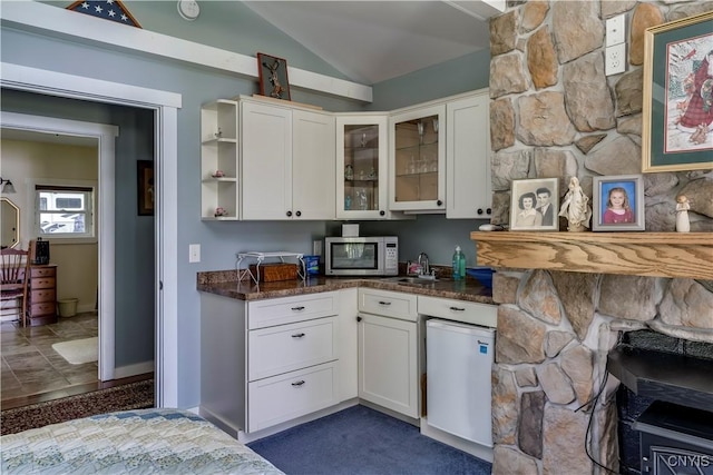 bar featuring stainless steel microwave, lofted ceiling, and a sink