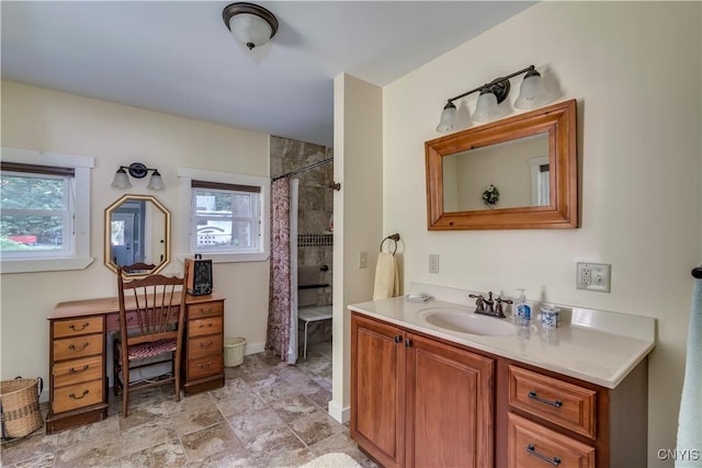 full bath featuring a tile shower and vanity