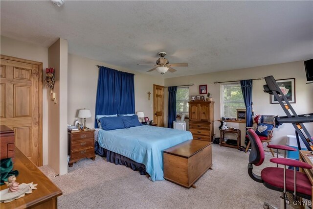 bedroom with a ceiling fan and light colored carpet