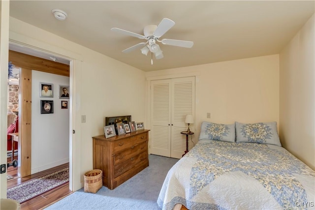 carpeted bedroom featuring ceiling fan and a closet