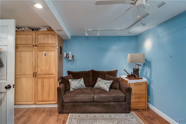 living room with light wood-style floors, ceiling fan, baseboards, and track lighting