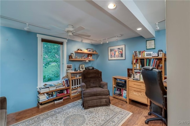 home office with a ceiling fan, wood finished floors, and rail lighting