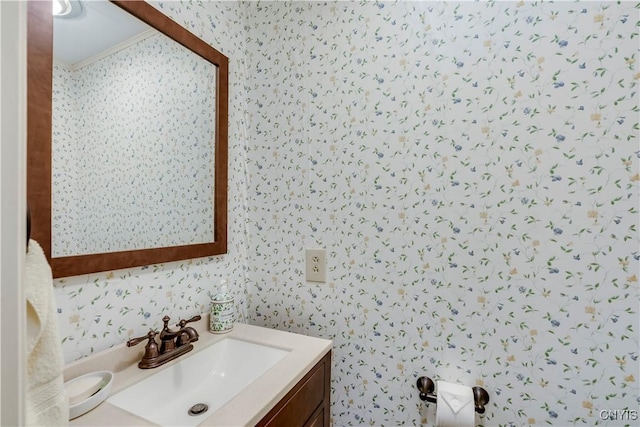 bathroom featuring wallpapered walls, vanity, and crown molding