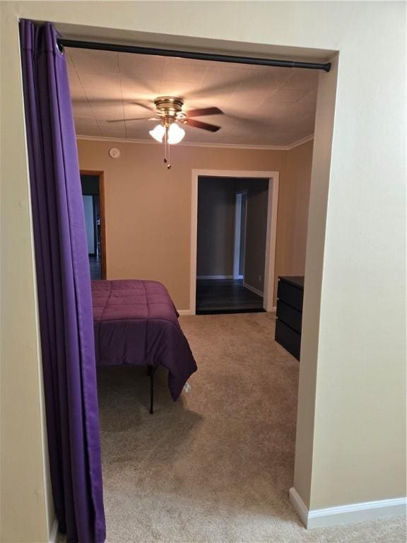 bedroom featuring carpet floors, crown molding, baseboards, and a ceiling fan