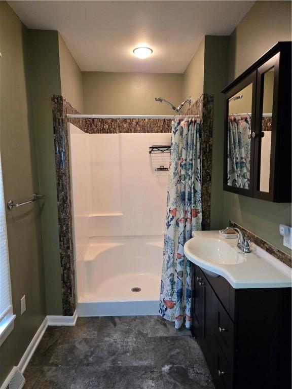 full bath with baseboards, visible vents, curtained shower, and vanity
