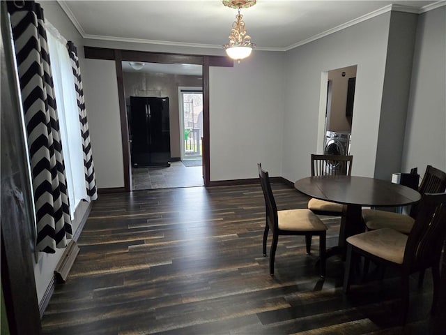 dining space with wood finished floors, baseboards, ornamental molding, and washer / clothes dryer