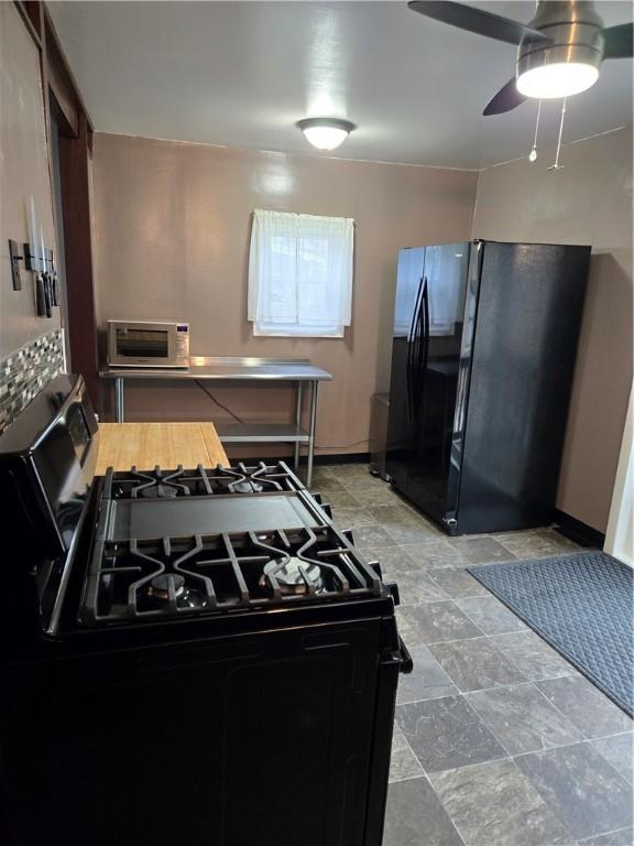 kitchen featuring black appliances, baseboards, a toaster, and ceiling fan