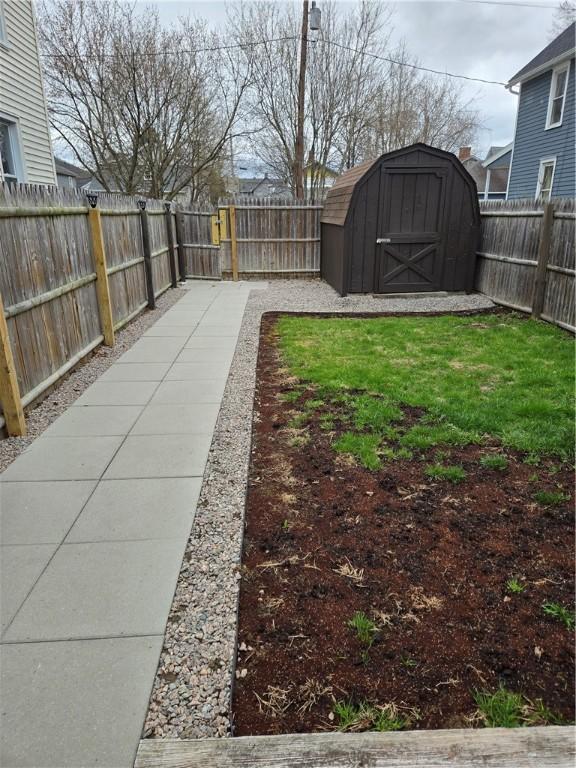 view of yard featuring a fenced backyard, an outbuilding, and a storage shed