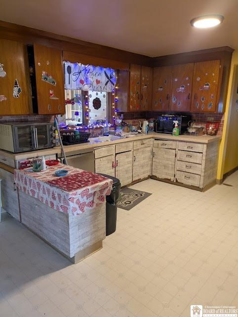 kitchen featuring light countertops, black microwave, and light floors