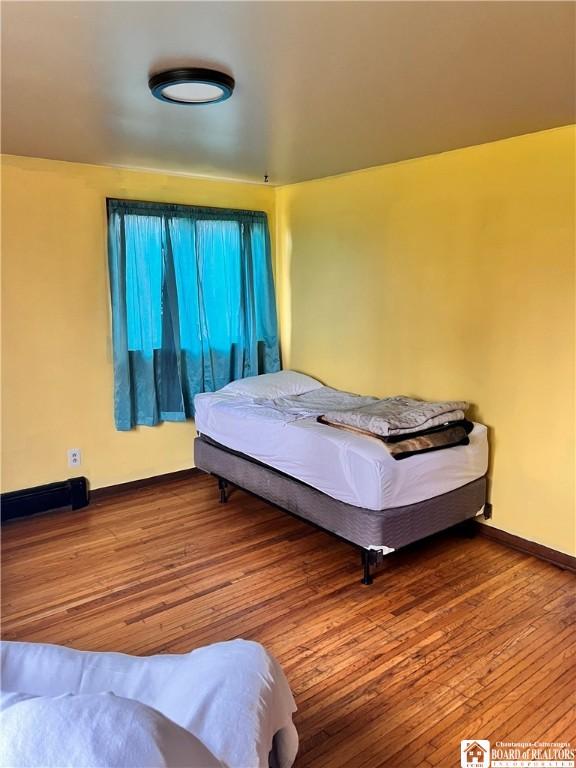 bedroom featuring hardwood / wood-style floors and baseboards