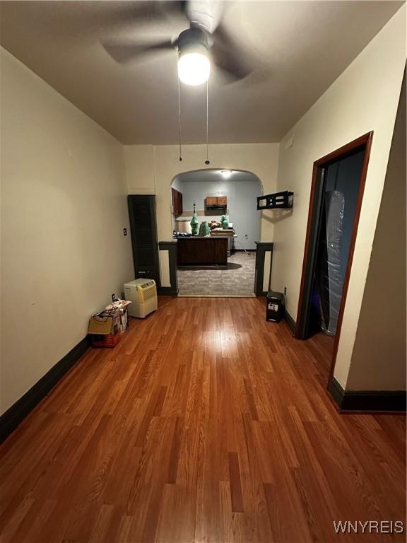 396 Guilford St, Buffalo, NY 14211 - unfurnished dining area featuring ceiling fan, arched walkways, wood finished floors, and baseboards