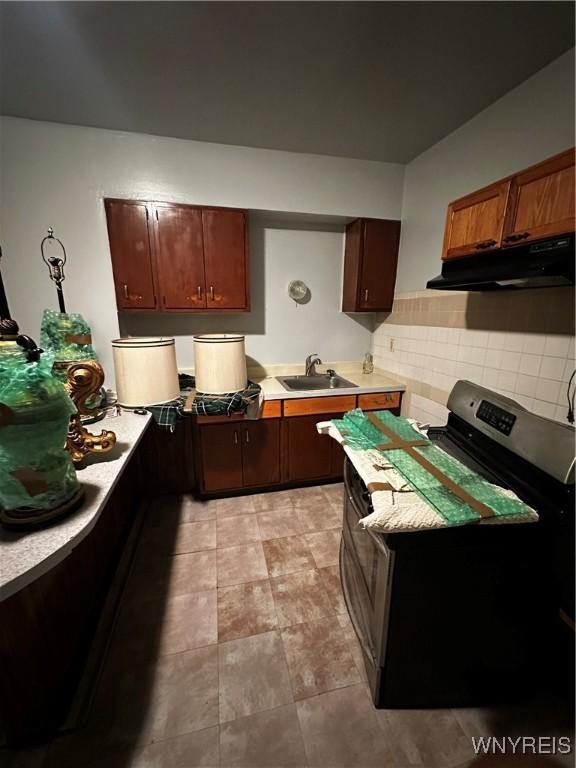 396 Guilford St, Buffalo, NY 14211 - kitchen featuring under cabinet range hood, light countertops, electric stove, a sink, and tasteful backsplash