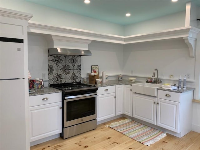 10 Orchard St Unit 8, Urbana, NY 14840 - kitchen with range hood, stainless steel stove, a sink, freestanding refrigerator, and light wood-style flooring