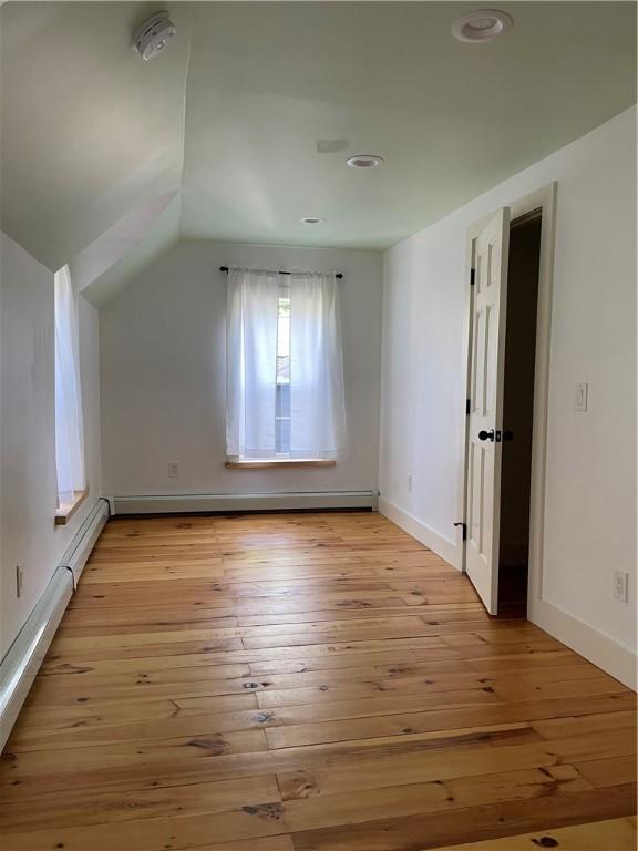 10 Orchard St Unit 8, Urbana, NY 14840 - additional living space with baseboard heating, baseboards, vaulted ceiling, and light wood-style flooring