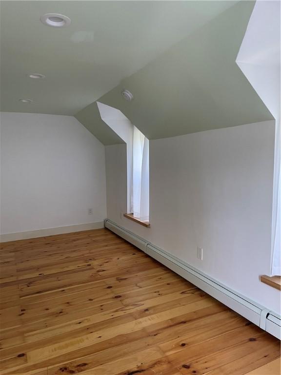 10 Orchard St Unit 8, Urbana, NY 14840 - additional living space with a baseboard radiator, recessed lighting, baseboards, light wood-type flooring, and vaulted ceiling