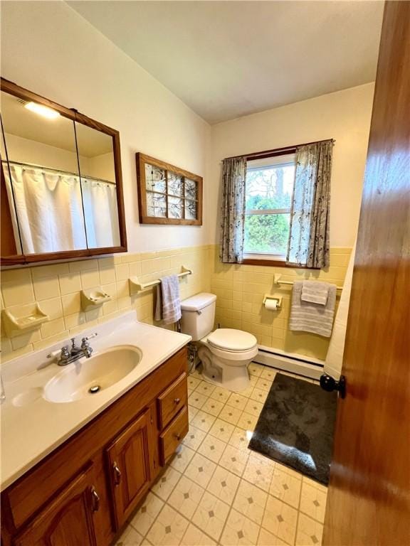 3460 County Road 28, Reading, NY 14891 - full bathroom with baseboard heating, wainscoting, vanity, tile walls, and toilet