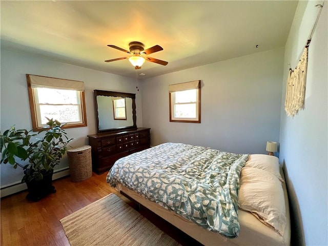 3460 County Road 28, Reading, NY 14891 - bedroom with a baseboard heating unit, ceiling fan, wood finished floors, and multiple windows