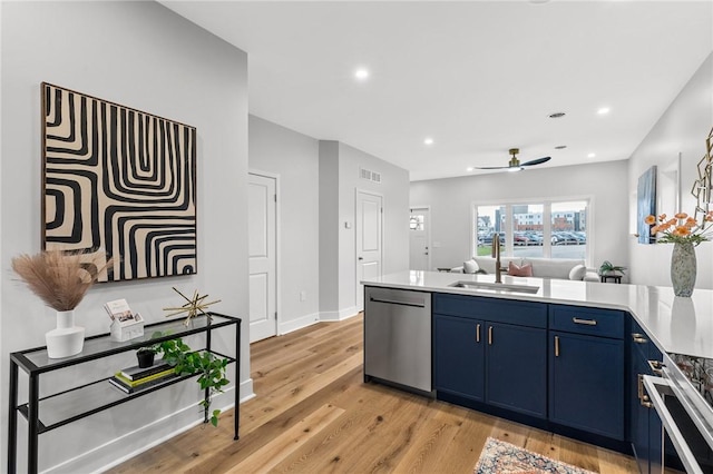 kitchen featuring blue cabinets, a sink, light wood-type flooring, ceiling fan, and appliances with stainless steel finishes