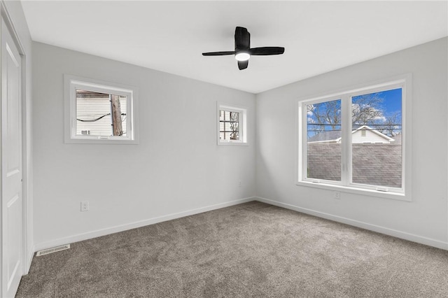 spare room featuring baseboards, a ceiling fan, carpet flooring, and visible vents