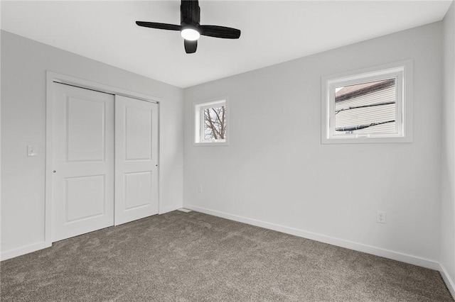 unfurnished bedroom with baseboards, carpet, and a closet