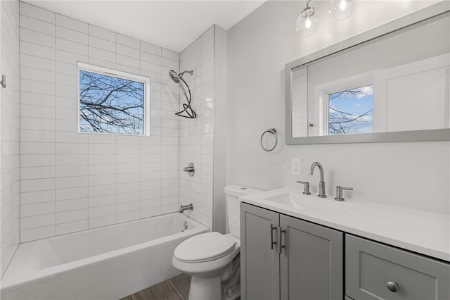 bathroom with toilet, vanity, wood finished floors, and shower / bath combination